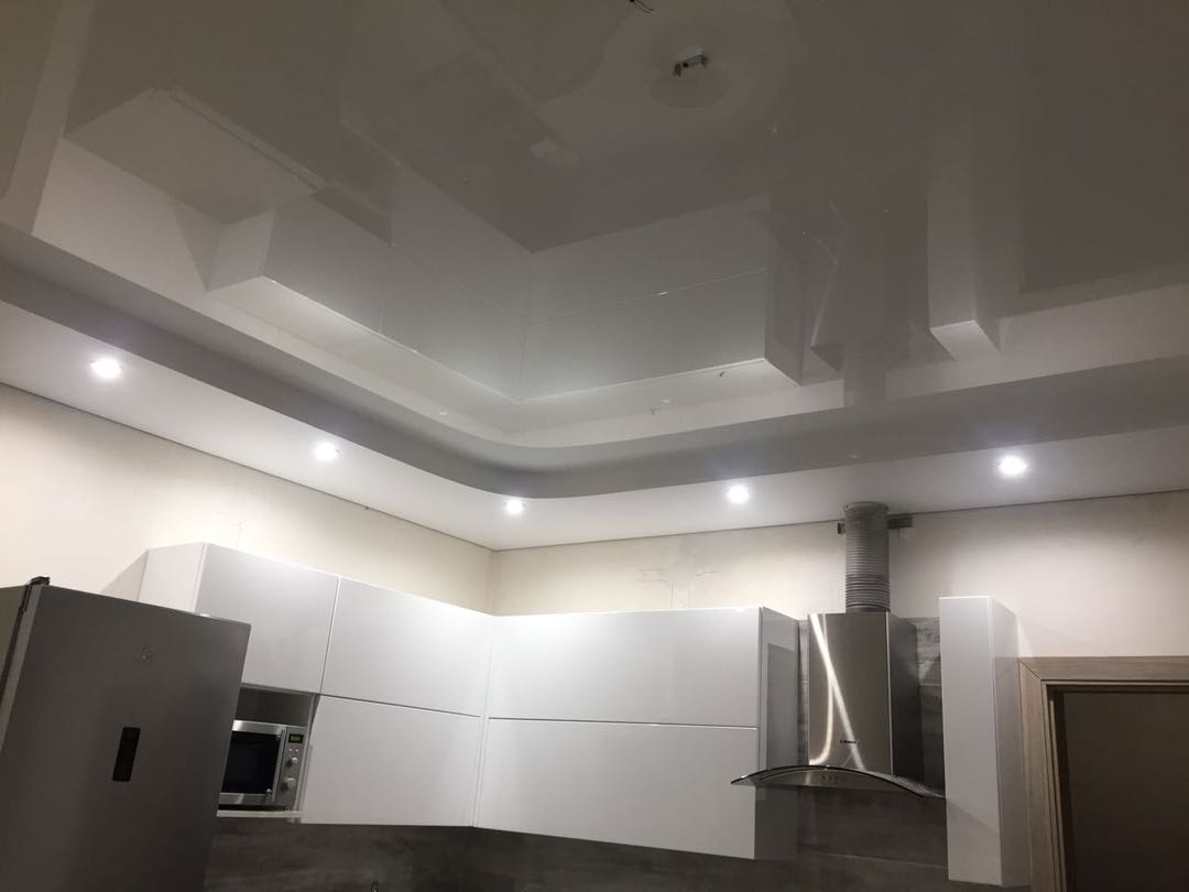 Глянцевый потолок на кухне в два уровня